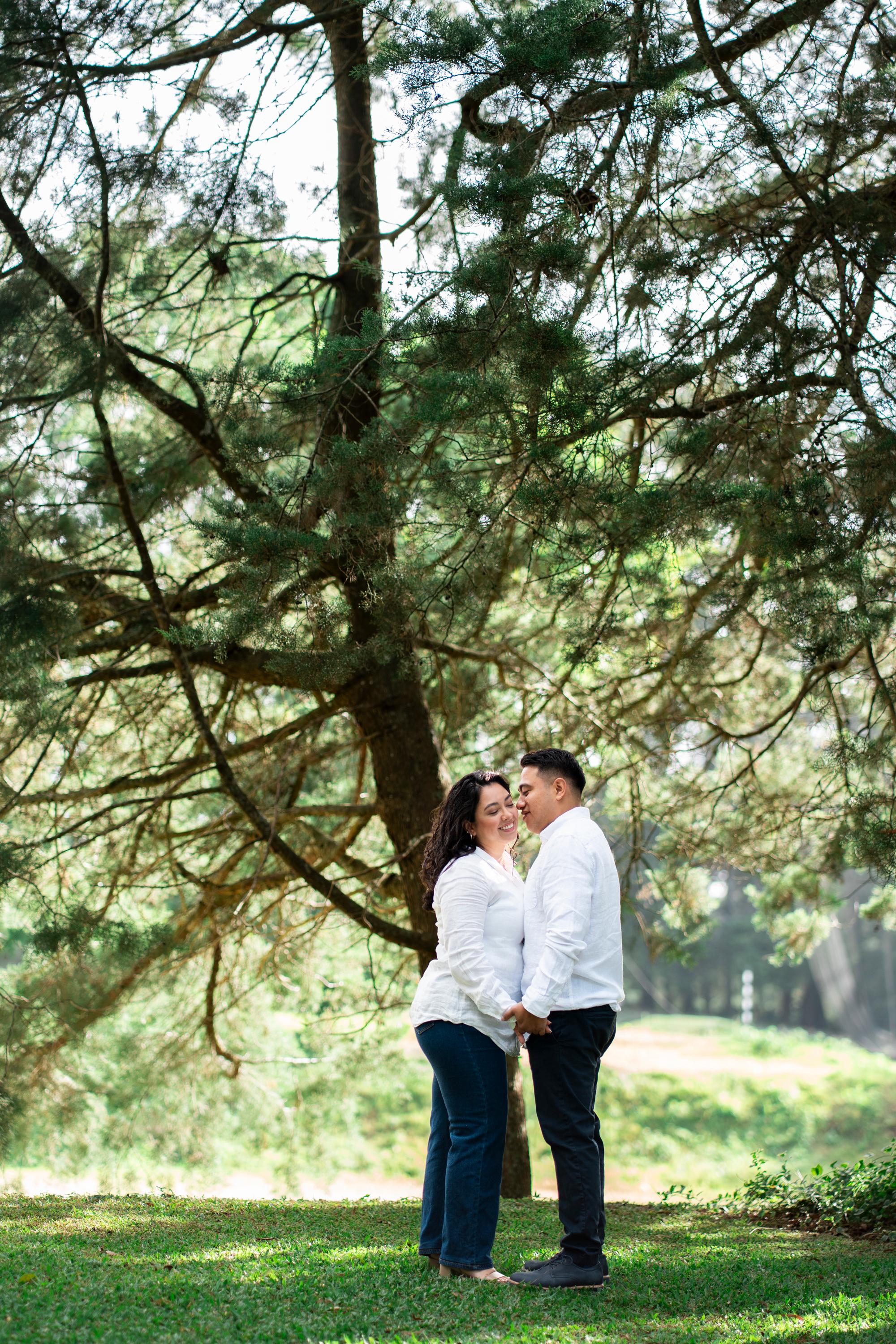 Celia y Adolfo abrazados bajo un árbol